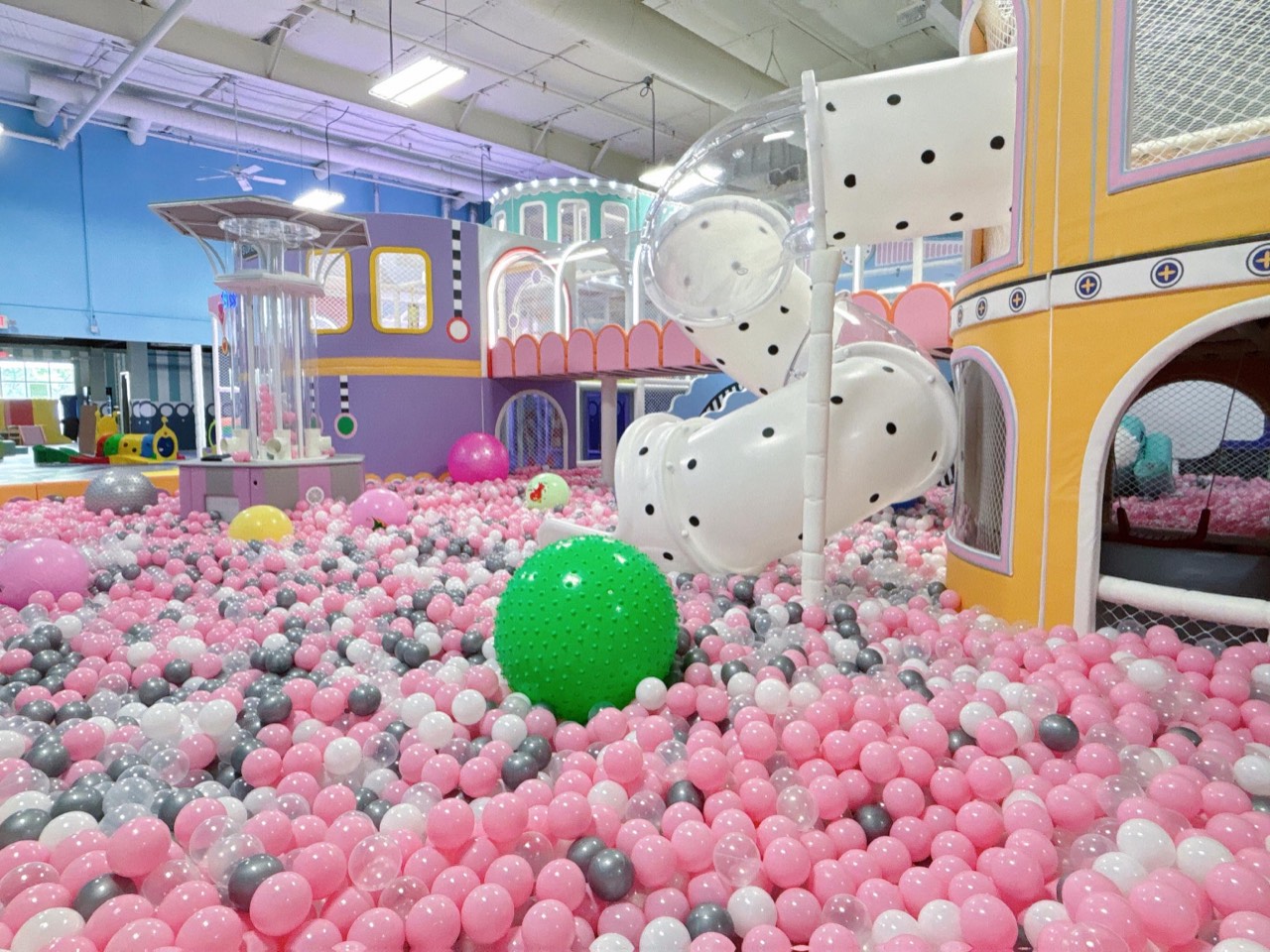 Pink ball pit with the colorful play structure at Little Playroom Cafe